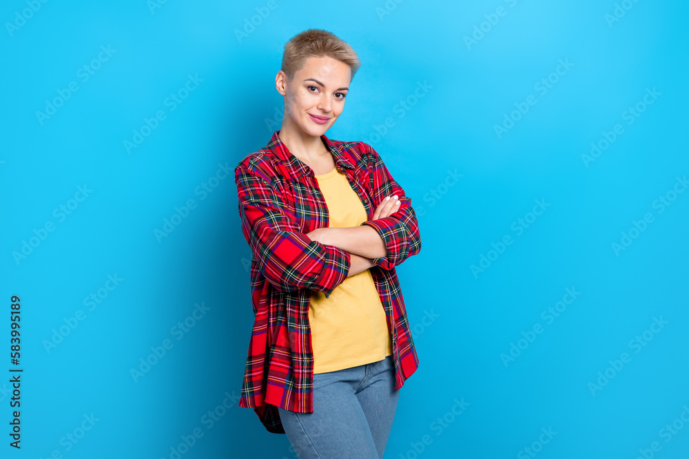 Portrait of good mood adorable woman with short hairdo wear checkered shirt holding arms crossed isolated on blue color background Portrait of good mood adorable woman with short hairdo wear checkered shirt holding arms crossed isolated on blue color background