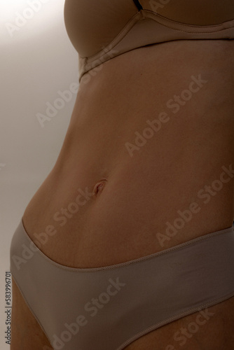 Close-up of a woman's belly. The toned body of a white woman and tanned skin.