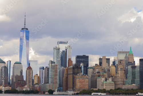 Beautiful view at Manhattan from river side. Skyscrapers on blue sky with white clouds background. New York. USA.