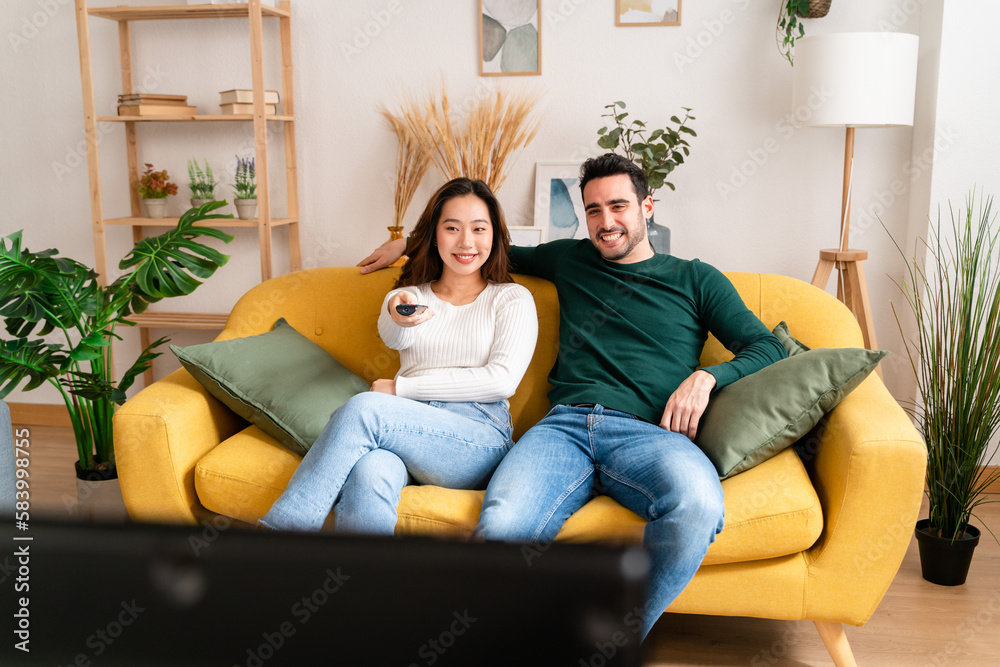 Happy couple hugging and watching TV in room