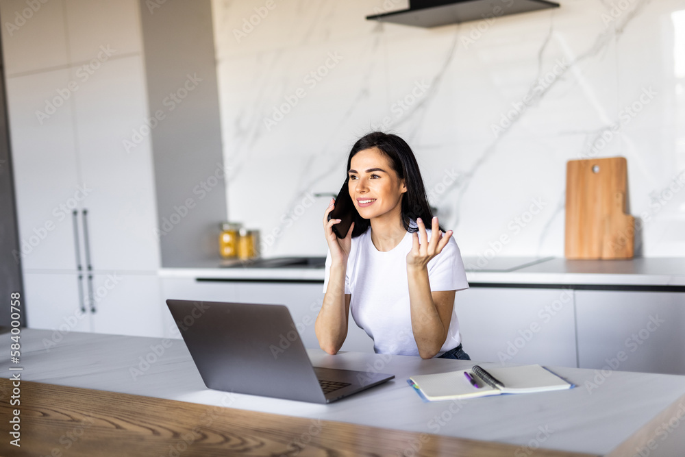 Beautiful young woman calling bank using cell phone concerning information on credit card that she is holding. Serious female connecting to mobile banking service using electronic device Beautiful young woman calling bank using cell phone concerning information on credit card that she is holding. Serious female connecting to mobile banking service using electronic device