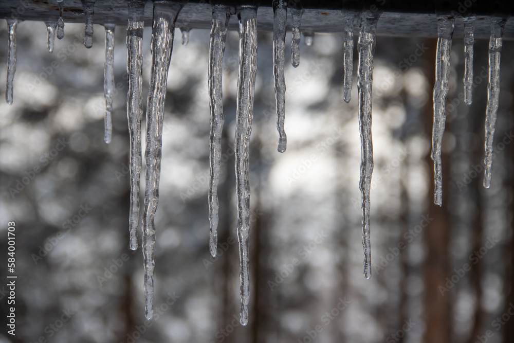 icicle hanging from the roof edge during the winter time icicle hanging from the roof edge during the winter time