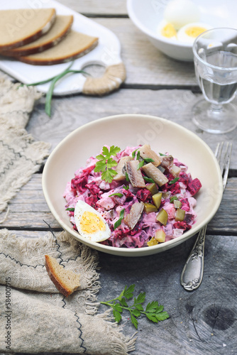 Heringsalat. Beetroot salad with herring, parsley and egg dressing photo