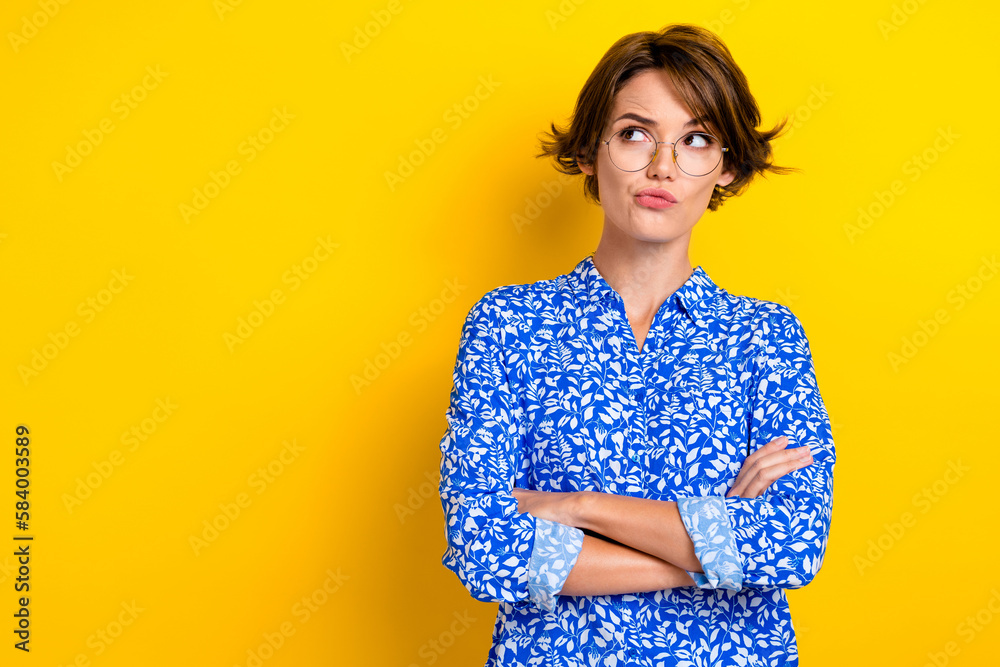 Photo of clever gorgeous lady wear trendy clothes suspiciously look empty space thinking buy eyewear isolated on yellow color background Photo of clever gorgeous lady wear trendy clothes suspiciously look empty space thinking buy eyewear isolated on yellow color background