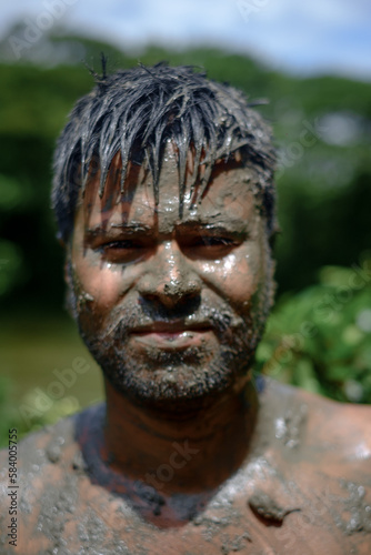 South asian hindu religious young aged handsome man playing with mud in bijoya dashami of Durga puja
 photo