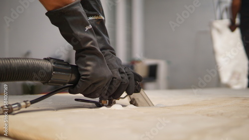 Close up of a man's hands in black gloves working cleaning sofa