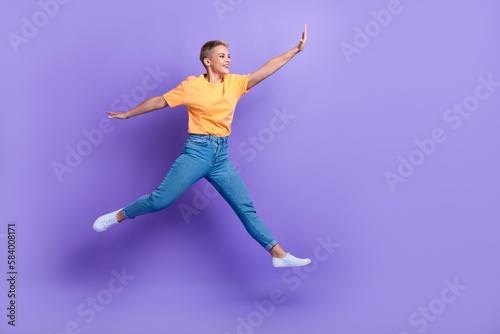Fototapeta Naklejka Na Ścianę i Meble -  Full length photo of pretty carefree person jumping look empty space isolated on violet color background