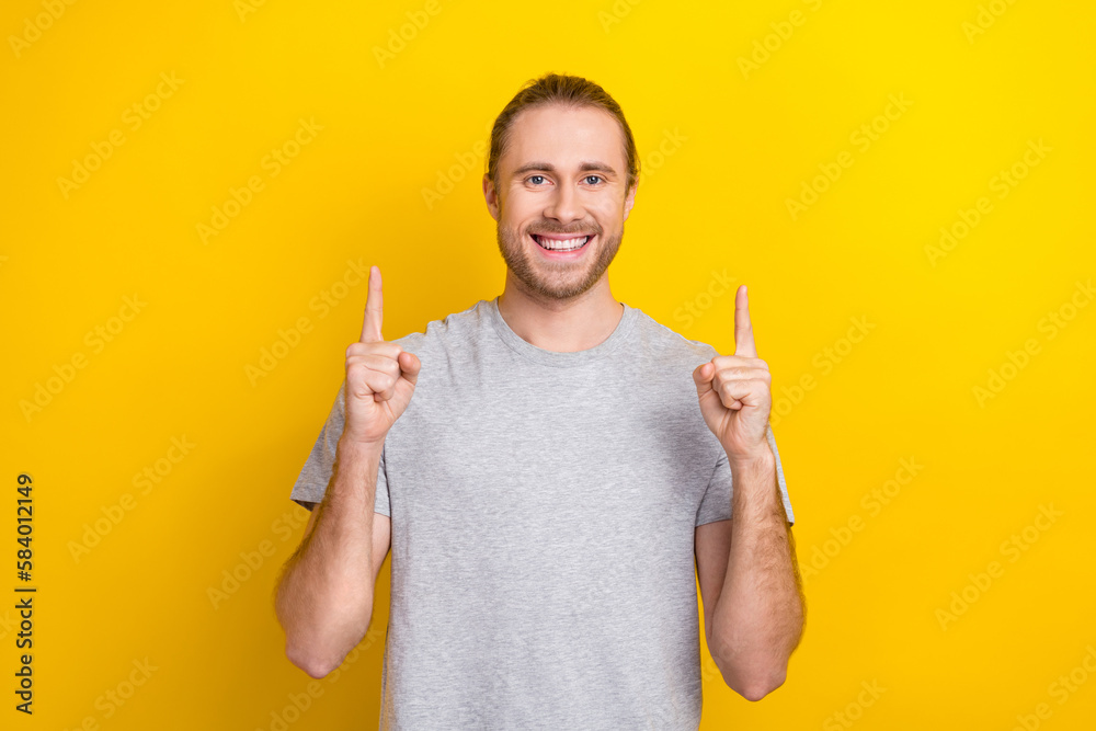 Photo of cheerful nice man wear grey quality stylish clothes two arm direct empty space special offer isolated on yellow color background