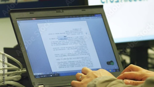 Employee works with text of script on laptop at workplace. Man modifies script for commentators in broadcast control room closeup