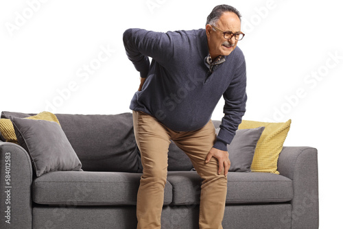 Mature man with back pain getting up from a sofa