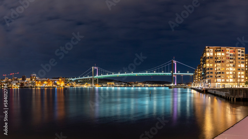  Gothenburg Midnight Skyline with Outlook over illuminated Alvsborgs Bridge reflecting in water of Gota Alv River in Sweden. 