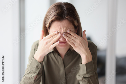 Bilde på lerret Woman rubs eyes with fingers feeling exhaustion after work