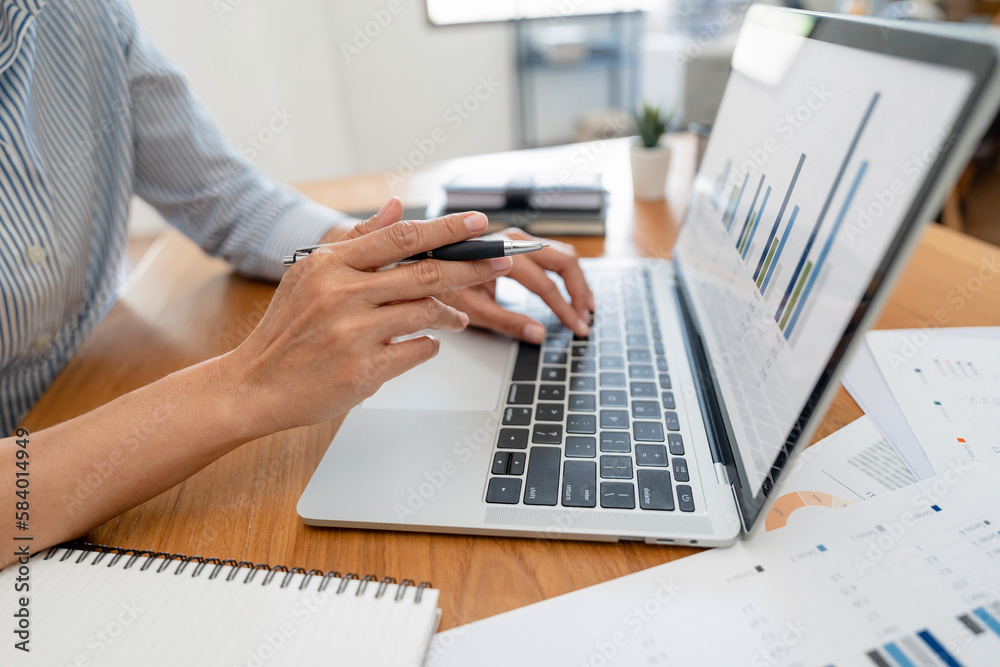 Hand holding pen pointing at laptop, online working corporate.. Hand holding pen pointing at laptop, online working corporate..