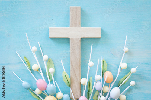 Cross and easter eggs on a blue wood background with copy space