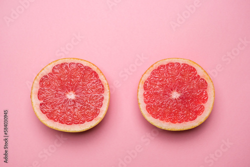 Juicy organic grapefruit cut in half on a pink background. Cool minimal flat lay, copy space. Healty breakfast or diet concept. (ID: 584030945)