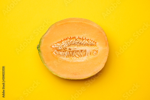 Half melon fresh organically grown on yellow background. Sweet and juicy summer fruit. Cool minimal flat lay, copy space (ID: 584033158)