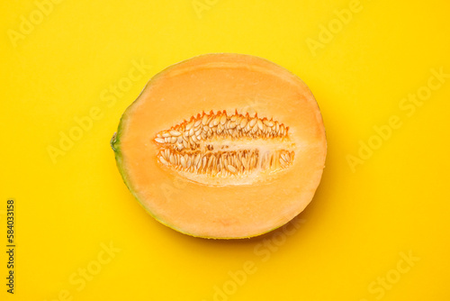 Half melon fresh organically grown on yellow background. Sweet and juicy summer fruit. Cool minimal flat lay, copy space