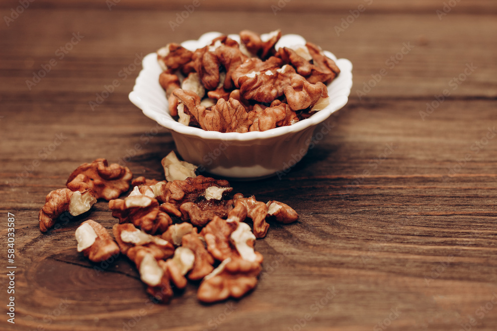 Dried walnut grains in a bowl on a wooden table.