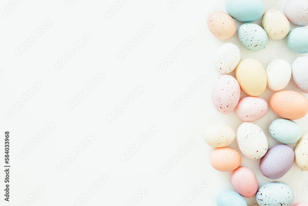 Border of pastel easter eggs on a white background with copy space
