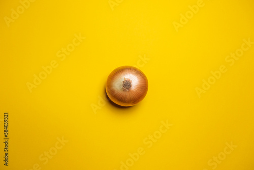 Organic whole white onion on a yellow background. Cool minimal flat lay, copy space