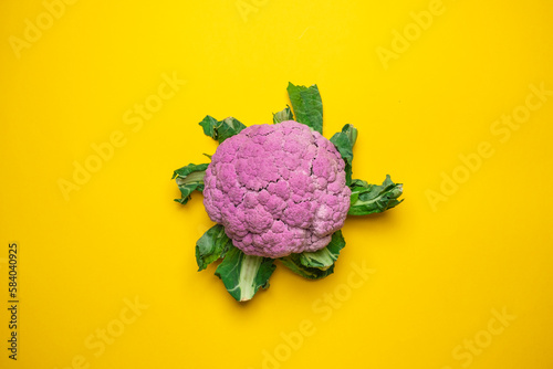 Pink cauliflower on a yellow background. Cool minimal flat lay, copy space.