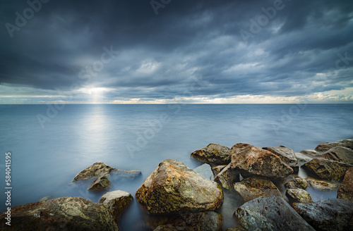 View of the lake from the boulders shore with impending rain and storm clouds at IJsselmeer Netherlands near the village Urk in Flevoland