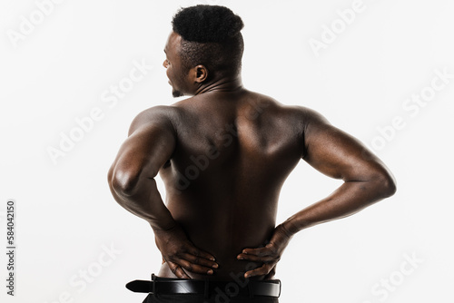 Muscular african american man feel backache spine pain because of UTI pyelonephritis disease on white background. Kidney infection pyelonephritis urinary tract infection.