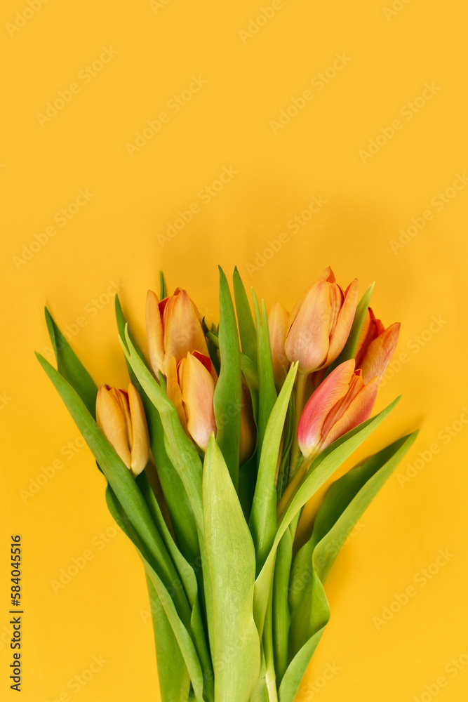 Flower bouquet with orange tulips on yellow background with copy space Flower bouquet with orange tulips on yellow background with copy space