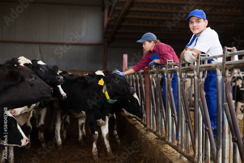 Young woman and young boy farmers posing in paddock at dairy farm © JackF