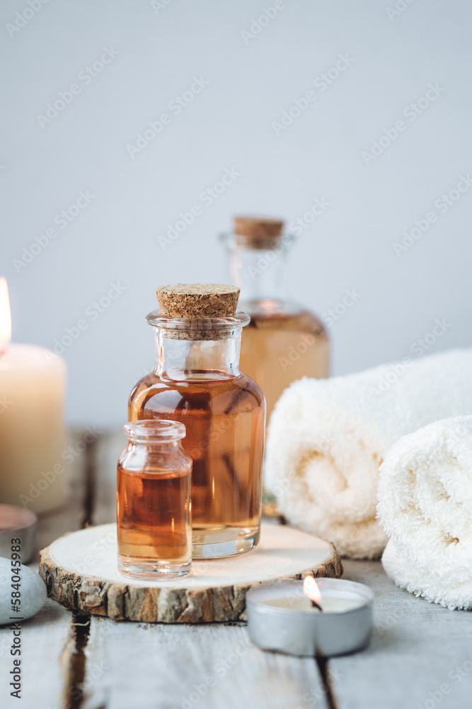 Concept of spa treatment in salon with pure organic natural oil. Atmosphere of relax, detention. Aromatherapy, candles, towel, wooden background. Skin care, body gentle treatment Concept of spa treatment in salon with pure organic natural oil. Atmosphere of relax, detention. Aromatherapy, candles, towel, wooden background. Skin care, body gentle treatment