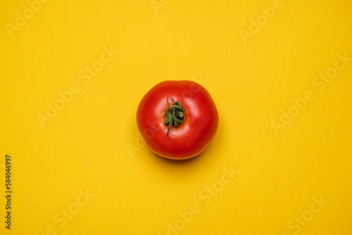 Red Tomato fresh organically grown on a yellow background. Cool minimal flat lay, copy space