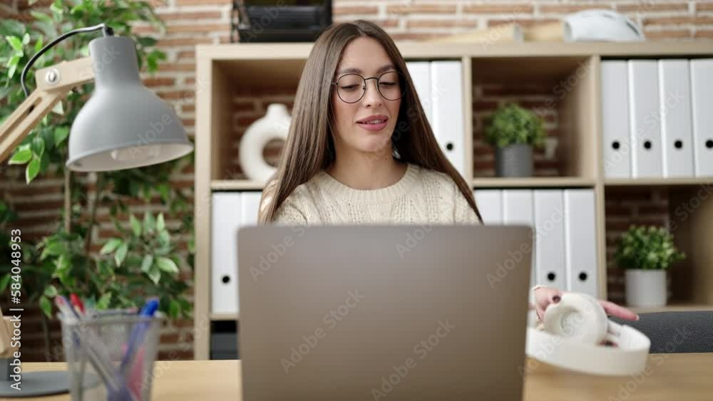 Young beautiful hispanic woman business worker using laptop and headphones working at office Young beautiful hispanic woman business worker using laptop and headphones working at office