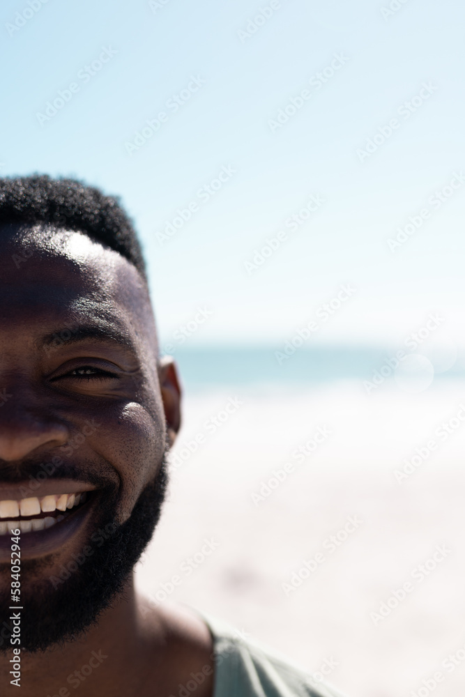 Cropped face of african american mid adult bearded man enjoying at beach against sea and clear sky