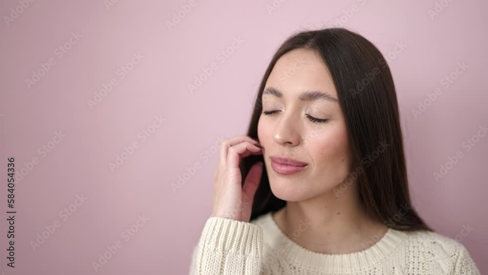 Young beautiful hispanic woman smiling confident touching face over isolated pink background Young beautiful hispanic woman smiling confident touching face over isolated pink background