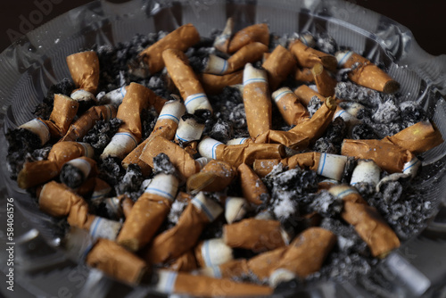 Cigarettes in an ashtray, ashes, many smoked cigarettes. A strong passion for smoking. Harmful to health. Smoking can be harmful to your health. It's a pity for the environment. Health problems.