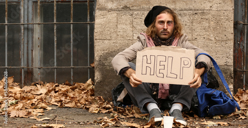 Poor homeless man holding c...