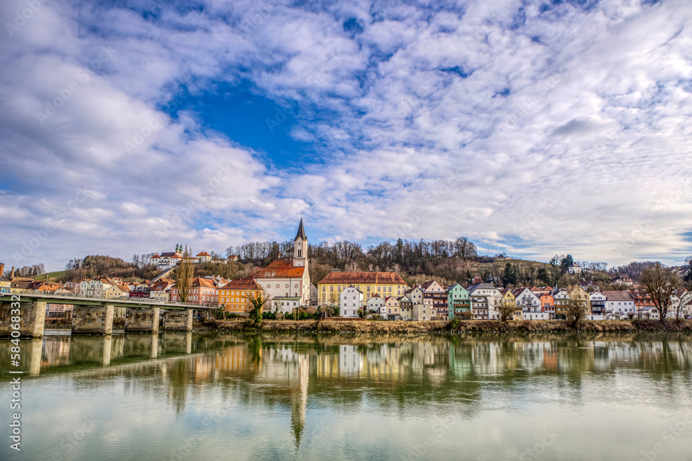 High dynamic range cityscape view of Passau city with view at the river inn and Innstadt district with church St. Gertraud in late afternoon sunlight in march