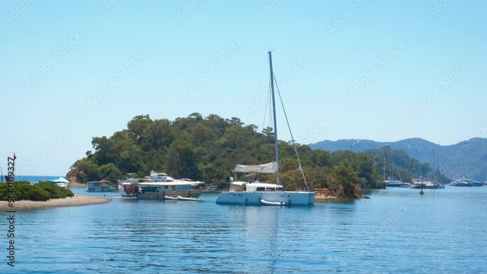 Fishing rest against tropical island. A view of some fishing boats resting by rocky summer island. A concept of sea summer trip during leisure time. Fishing rest against tropical island. A view of some fishing boats resting by rocky summer island. A concept of sea summer trip during leisure time.