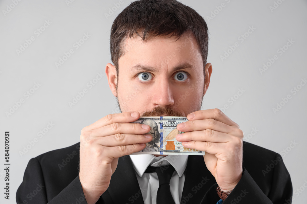 Businessman with bribe on grey background, closeup Businessman with bribe on grey background, closeup