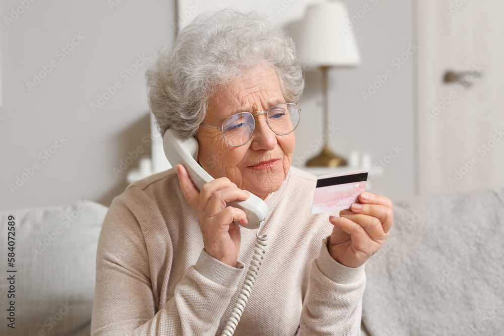 Senior woman with credit card talking by telephone at home, closeup Senior woman with credit card talking by telephone at home, closeup