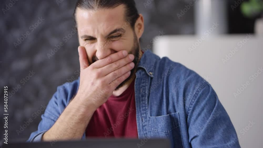 young guy worker freelancer working at laptop typing tired rubbing eyes yawning close-up young guy worker freelancer working at laptop typing tired rubbing eyes yawning close-up
