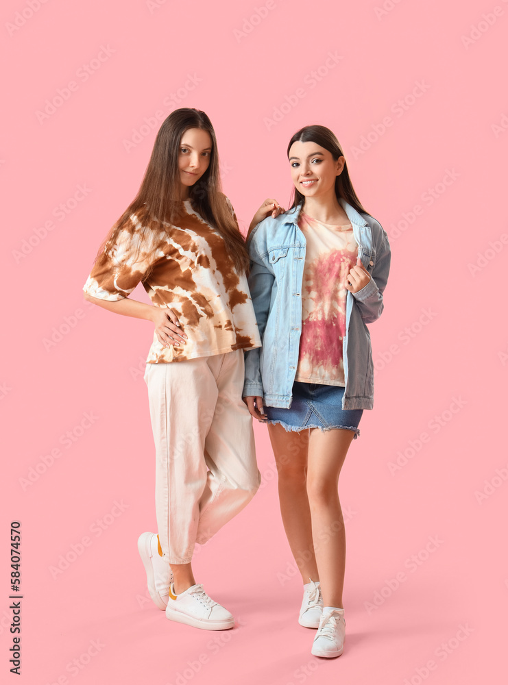 Stylish young women in tie-dye t-shirts on pink background Stylish young women in tie-dye t-shirts on pink background
