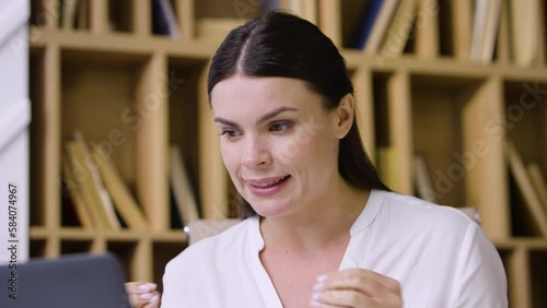 A young female teacher a language teacher conducts an online zoom class a webinar teaches the correct pronunciation of words articulates shows the correct pronunciation close-up