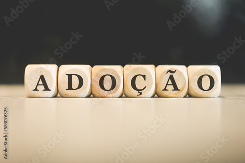 A palavra adoção em Português do Brasil escrita em dados de madeira. photo