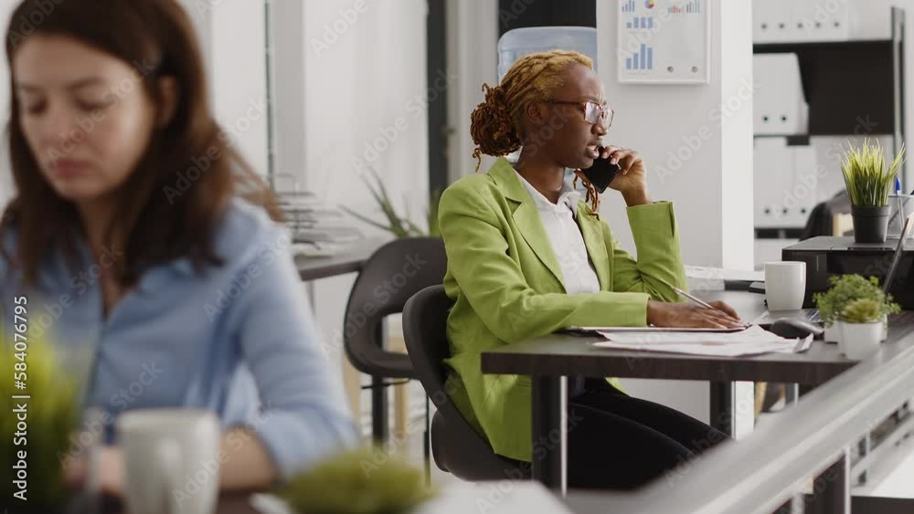 African american adult using phone call in startup office, talking to manager about investment plan. Company employee having remote conversation in workplace, chatting on telephone line. African american adult using phone call in startup office, talking to manager about investment plan. Company employee having remote conversation in workplace, chatting on telephone line.
