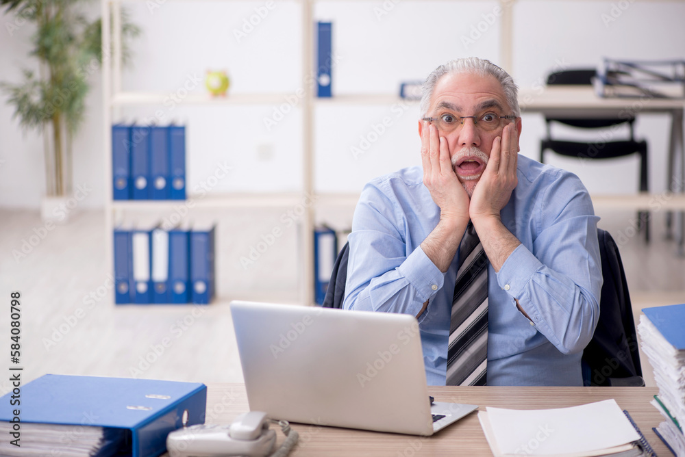 Old male employee working in the office Old male employee working in the office