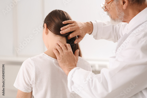 Professional orthopedist examining patient's neck in clinic, closeup