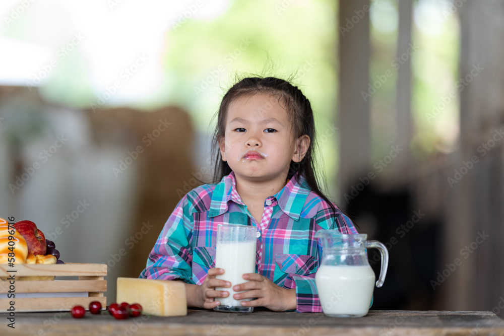 Asian girl drinking Fresh cow's milk that is produced from modern farms and dairy products. , product concepts from dairy farms and health Asian girl drinking Fresh cow's milk that is produced from modern farms and dairy products. , product concepts from dairy farms and health