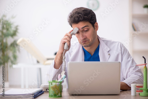 Young male dentist working in the clinic