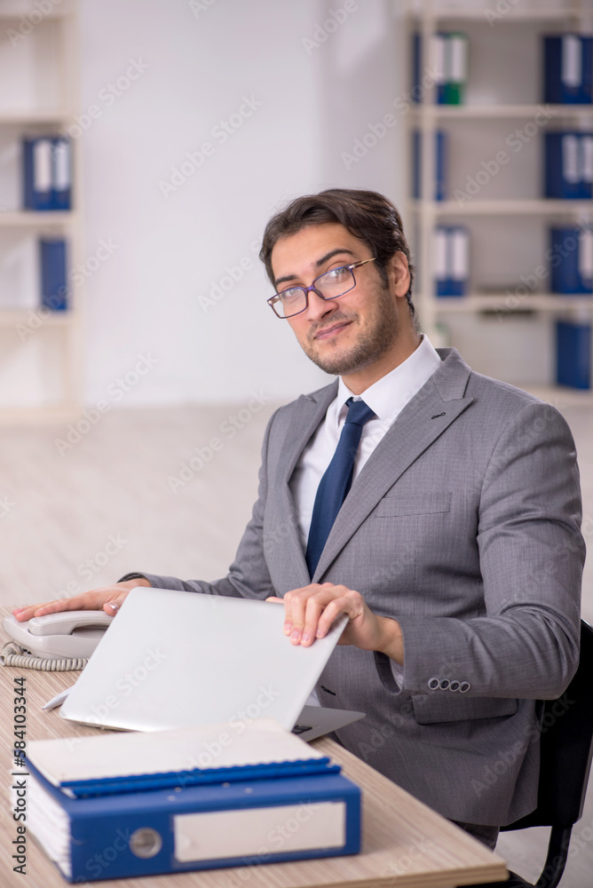 Young male employee working in the office Young male employee working in the office